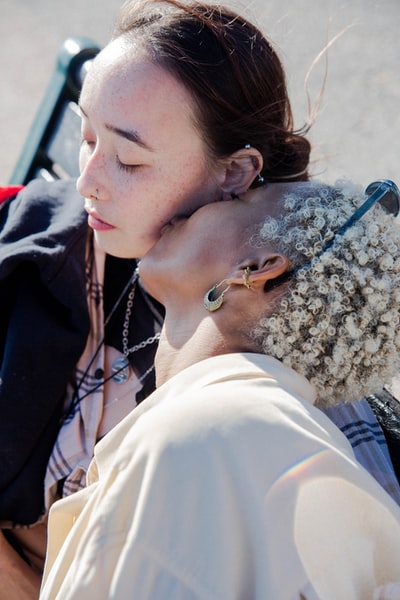 The woman of the white shirt to kiss a woman in a black shirt
